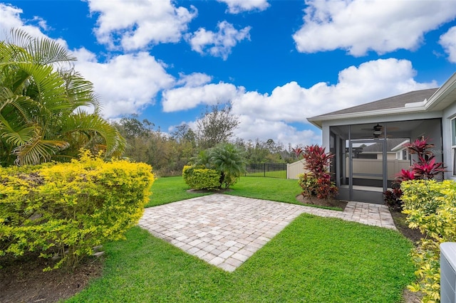 view of yard with ceiling fan, a patio, fence, and a sunroom