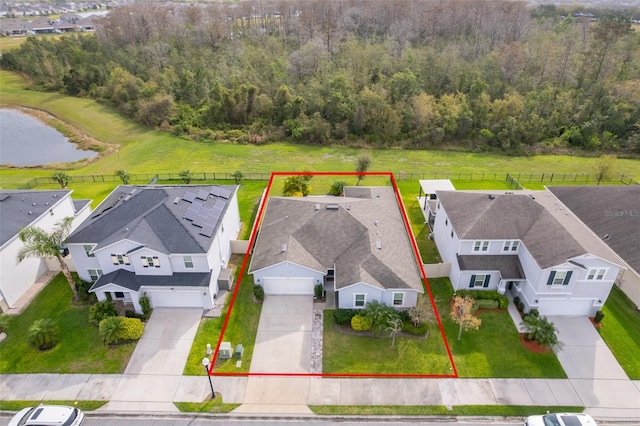 aerial view with a residential view, a water view, and a view of trees