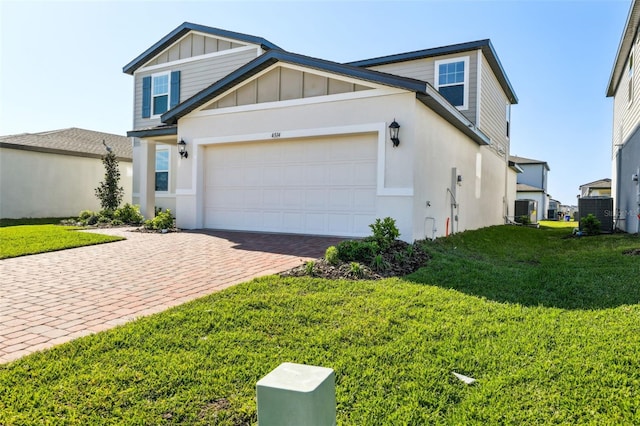 view of front facade with board and batten siding, a front lawn, decorative driveway, a garage, and central AC