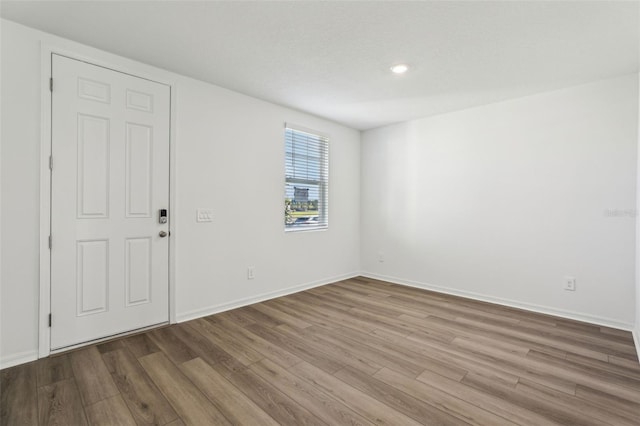 unfurnished room with baseboards and wood finished floors