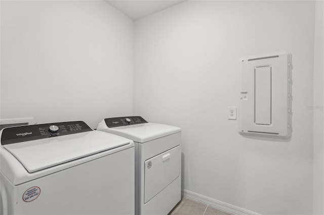 washroom featuring washer and clothes dryer, laundry area, baseboards, and light tile patterned floors
