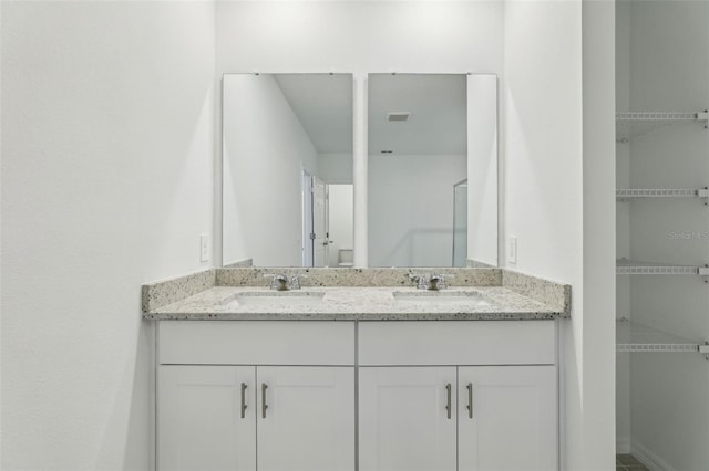 full bathroom with double vanity, visible vents, and a sink