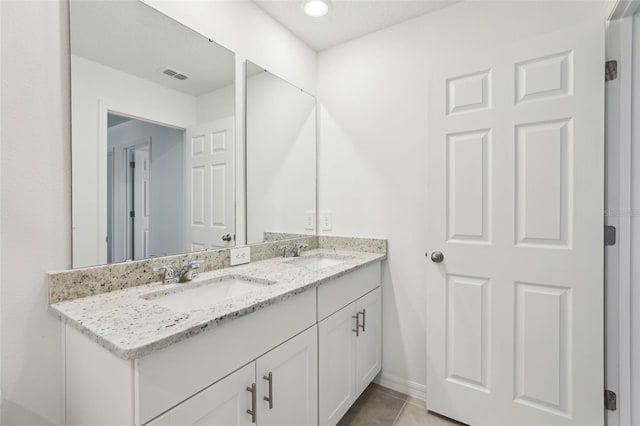 bathroom featuring double vanity, a sink, tile patterned floors, and visible vents