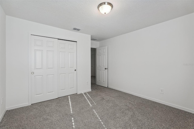 unfurnished bedroom featuring baseboards, a closet, and a textured ceiling