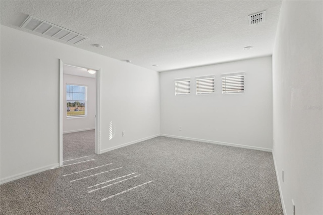spare room with visible vents, carpet flooring, and a healthy amount of sunlight