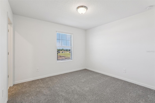 unfurnished room featuring carpet flooring, baseboards, and a textured ceiling