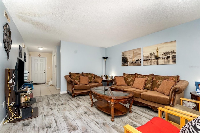 living area featuring a textured ceiling, visible vents, and light wood-style flooring