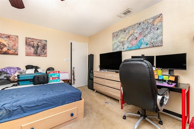 bedroom featuring light carpet, a ceiling fan, visible vents, and a textured ceiling