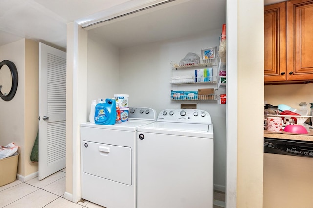 clothes washing area featuring light tile patterned floors, baseboards, and independent washer and dryer