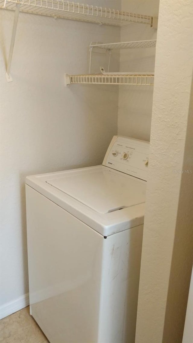 clothes washing area featuring washer / dryer, baseboards, and laundry area