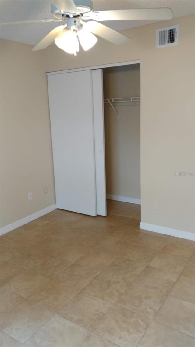 unfurnished bedroom featuring ceiling fan, a closet, visible vents, and baseboards