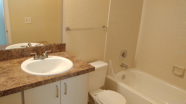 full bath with a textured wall, vanity, toilet, and shower / bathtub combination