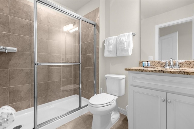 full bathroom featuring toilet, a shower stall, vanity, and tile patterned floors