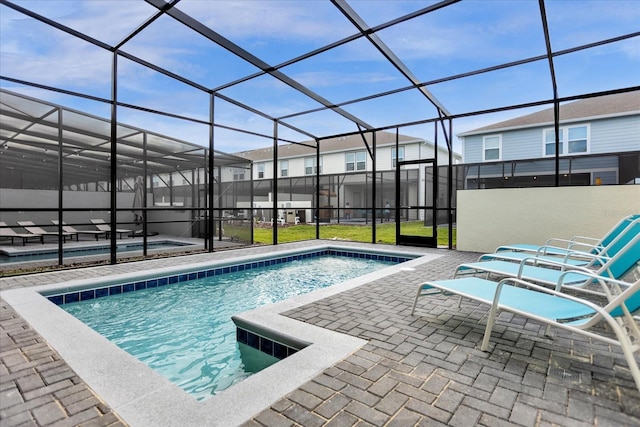 pool with glass enclosure, a residential view, and a patio