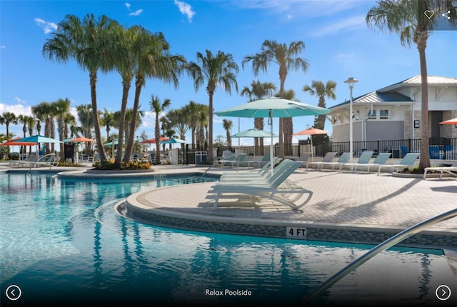 community pool with a patio and fence