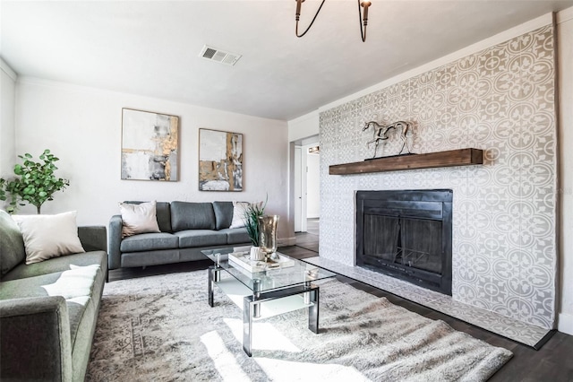 living room with a fireplace, wood finished floors, and visible vents