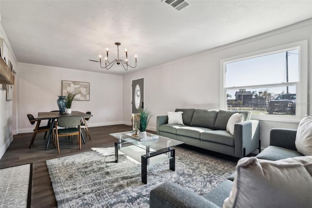 living room with dark wood-style floors, baseboards, visible vents, and a notable chandelier