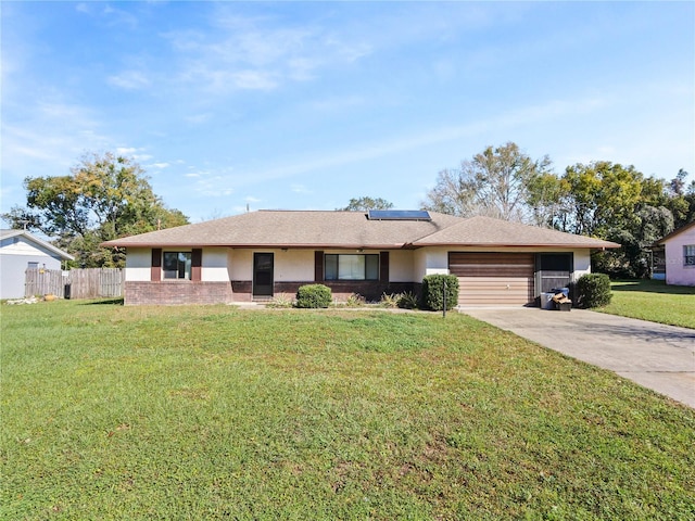 ranch-style home with driveway, a front yard, fence, roof mounted solar panels, and brick siding