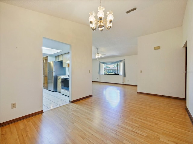 empty room featuring light wood-style floors, baseboards, visible vents, and ceiling fan with notable chandelier