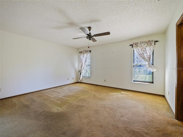 empty room with a ceiling fan, light carpet, a textured ceiling, and baseboards