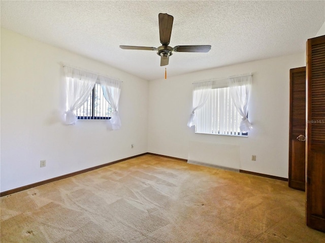 unfurnished bedroom with ceiling fan, a textured ceiling, baseboards, and carpet flooring