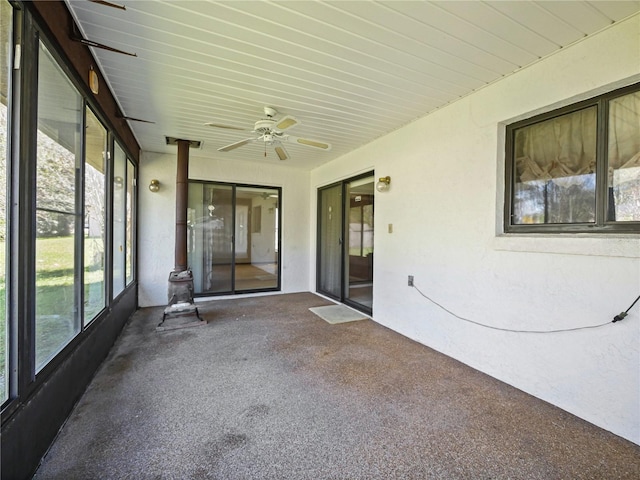 unfurnished sunroom with ceiling fan