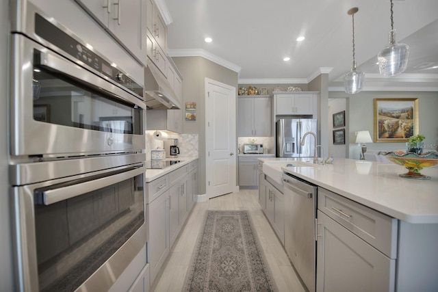 kitchen featuring decorative backsplash, appliances with stainless steel finishes, light countertops, crown molding, and pendant lighting