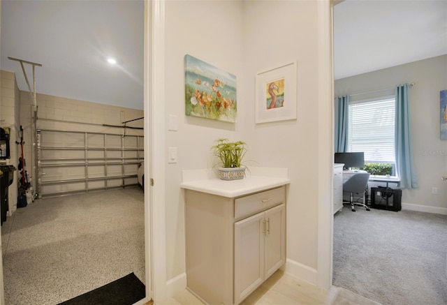 interior space featuring light carpet and baseboards