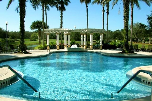 community pool with a patio area and a pergola