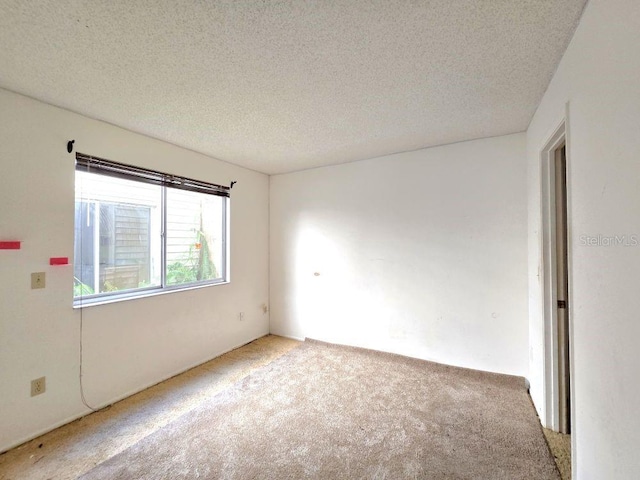 carpeted spare room with a textured ceiling