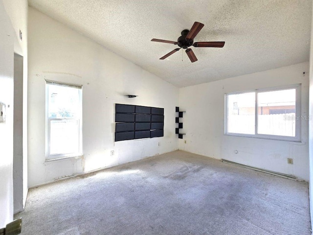 spare room featuring a ceiling fan, light carpet, high vaulted ceiling, and a textured ceiling