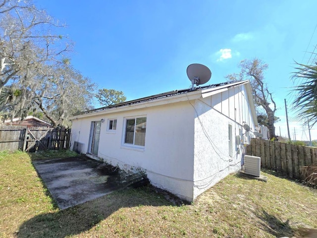 back of house with fence, central AC, and a yard