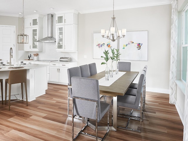 dining room with ornamental molding, light wood-type flooring, and baseboards