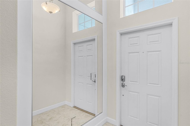 entrance foyer featuring a high ceiling and baseboards