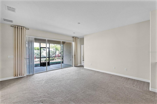 spare room featuring carpet flooring, visible vents, and baseboards