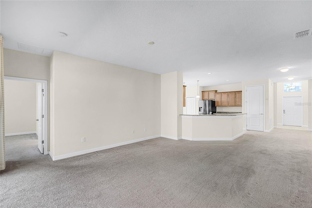 unfurnished living room with light carpet, visible vents, and baseboards