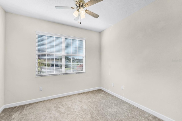 spare room with carpet floors, ceiling fan, and baseboards