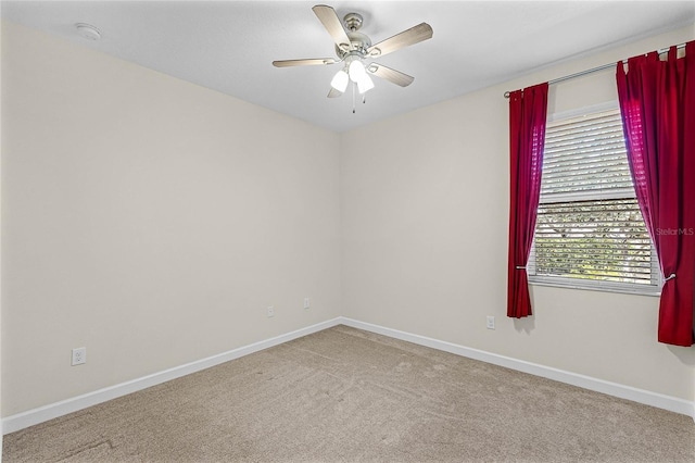 unfurnished room with carpet flooring, a ceiling fan, and baseboards