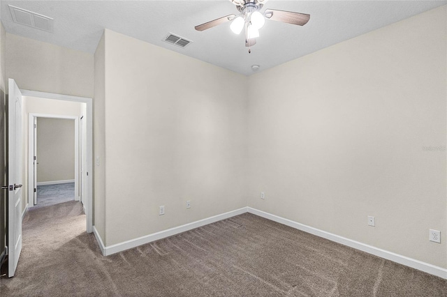 carpeted empty room featuring baseboards, visible vents, and ceiling fan