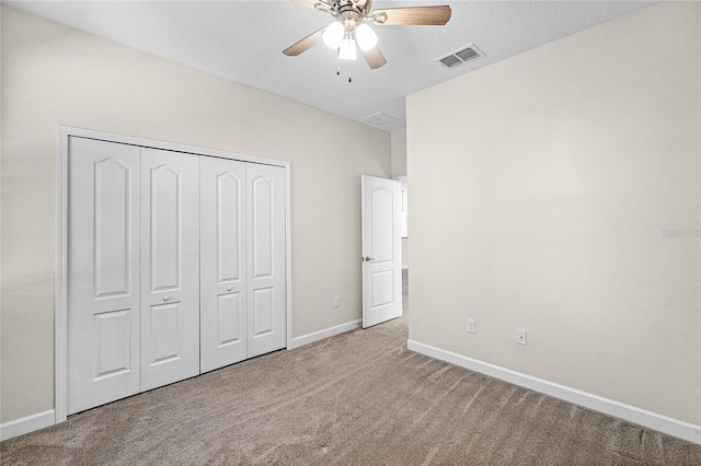 unfurnished bedroom featuring carpet, a closet, visible vents, and baseboards