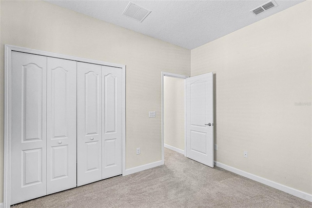 unfurnished bedroom with carpet flooring, visible vents, and baseboards