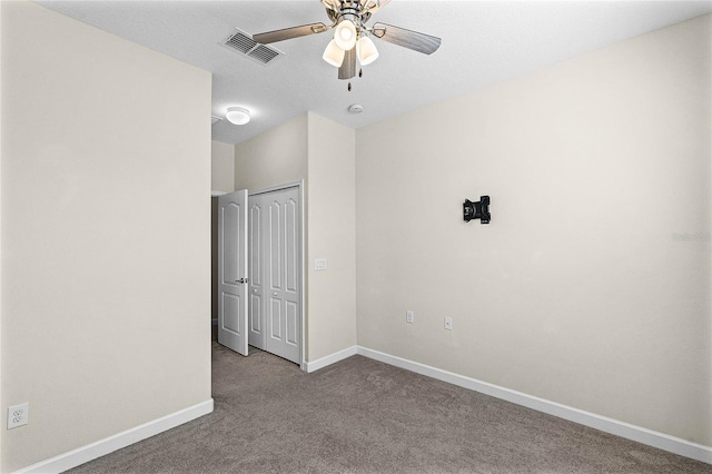 unfurnished bedroom with baseboards, visible vents, ceiling fan, carpet floors, and a closet