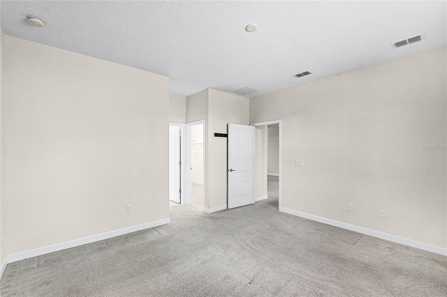 unfurnished bedroom with carpet floors, baseboards, and visible vents