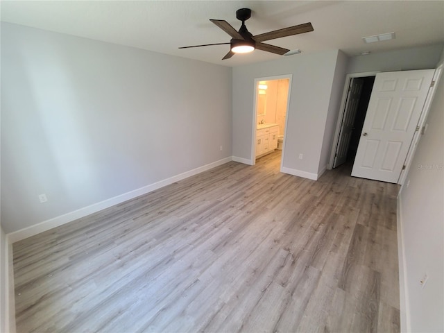 unfurnished bedroom with baseboards, visible vents, ensuite bath, ceiling fan, and light wood-style floors