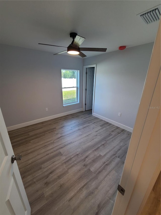 spare room featuring light wood-style flooring, visible vents, and baseboards