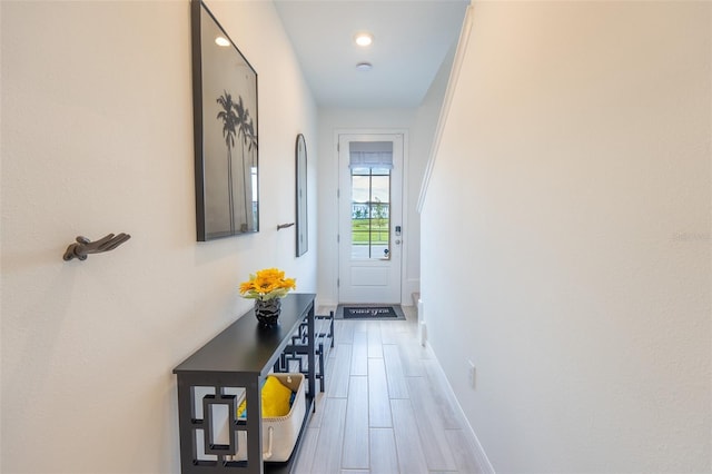 doorway to outside with wood finished floors and baseboards