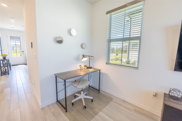 home office with baseboards and wood finish floors