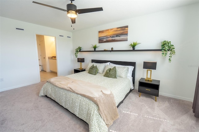 carpeted bedroom featuring a ceiling fan, visible vents, baseboards, and ensuite bathroom