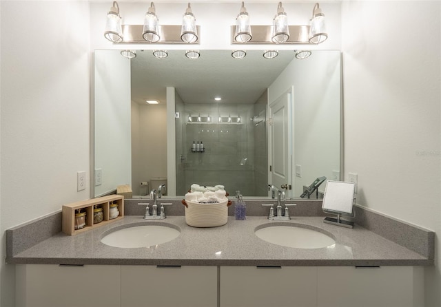 full bathroom featuring toilet, a shower stall, double vanity, and a sink