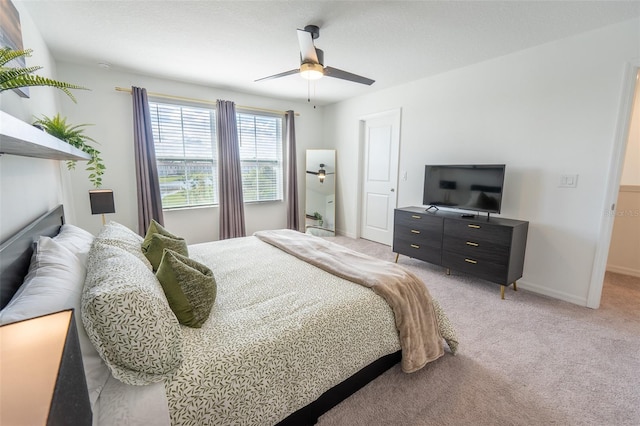 bedroom featuring baseboards, ceiling fan, and light colored carpet